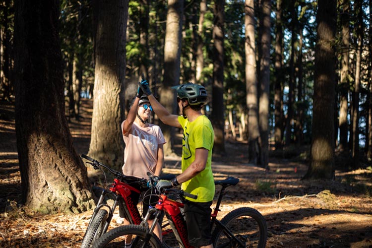 A couple is out and about in the forest with their e-bikes