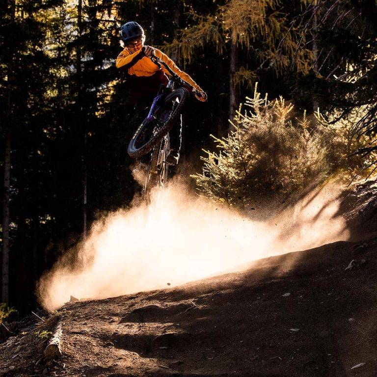 Bike rental Klante in Winterberg 4 Man jumps with MTB in the forest against the light - mountain bike rental Klante-Winterberg